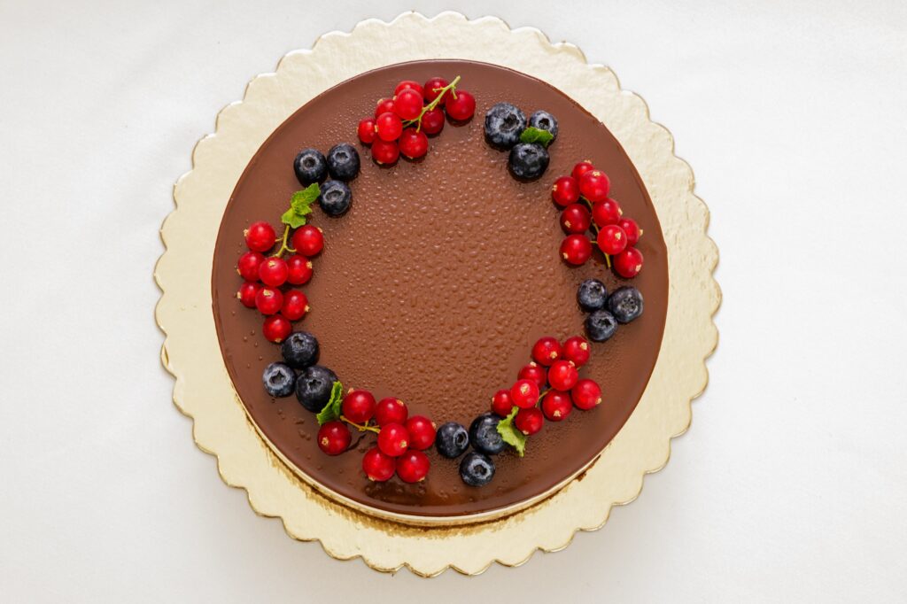 Tort cu glazură de ciocolată, decorat cu fructe de pădure, vedere de sus.