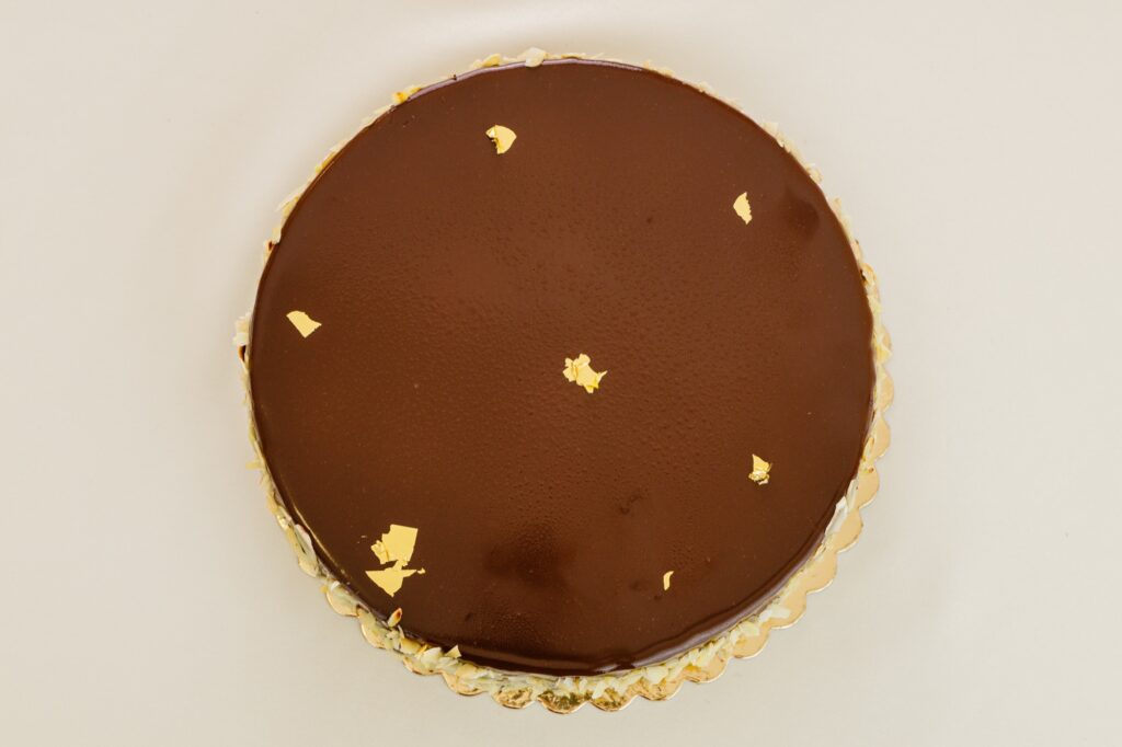 Tort cu glazură de ciocolată și foiță de aur.