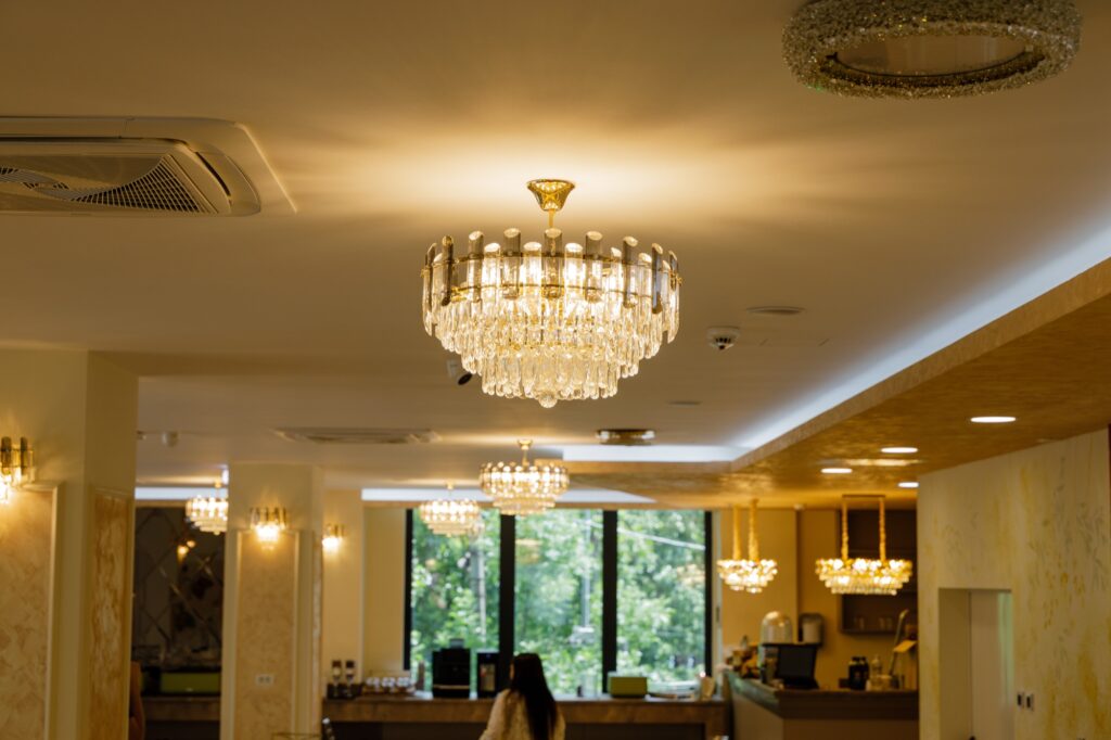 Hol elegant cu candelabre de cristal și recepție, cu vedere spre pădure.