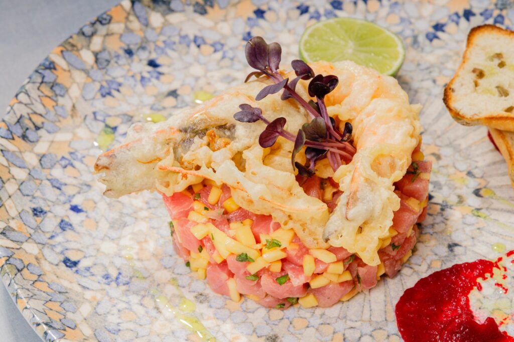 Tartar de ton cu mango și creveți în tempura crocantă, decorat cu microplante și lime
